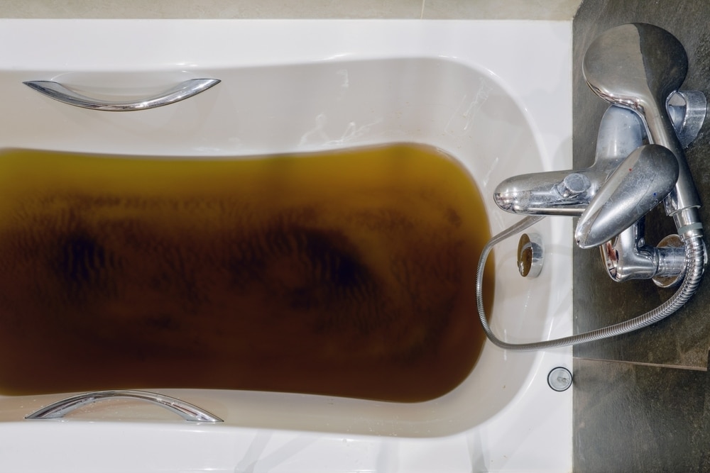 A bathtub filled with dirty water due to a clogged sewer pipe